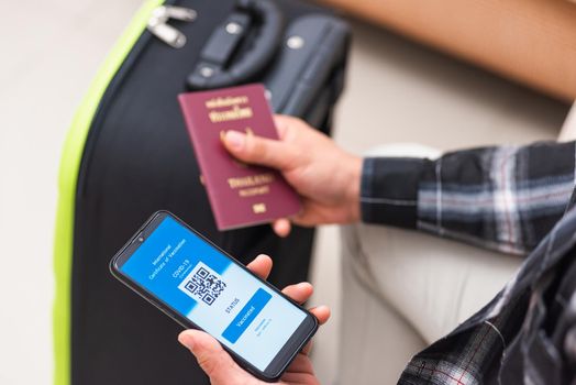 Vaccination passport, Traveler man holding health passport of vaccination certification on smartphone app at airport before boarding plane during coronavirus pandemic, Mobile app of virus COVID-19