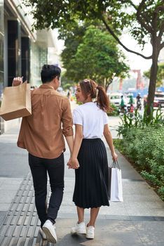 Young happy couple with shopping bags in the city. 
