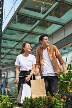 Beautiful young loving couple carrying shopping bags and enjoying together. 