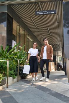 Beautiful young loving couple carrying shopping bags and enjoying together. 