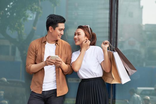 A picture of a couple shopping with smartphone in the city 