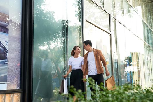 Young happy couple with shopping bags in the city.