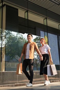 Young happy couple with shopping bags in the city. 