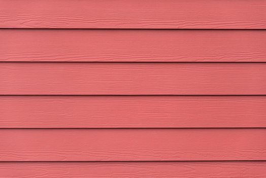 Red colored siding backdrop with wooden plank texture.