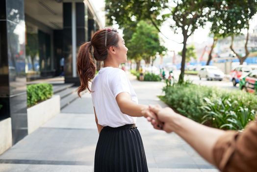 Young woman is holding his couple's hand on Le Loi Road in Hochiminh city.