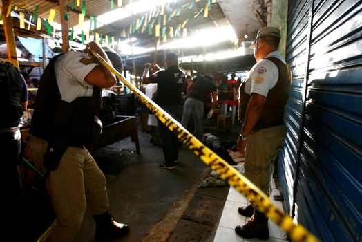 salvador, bahia, brazil - march 24, 2015: Investigators from the homicide department and experts carry out the cadaveric survey on a man murdered by knife blows in the city of Salvador.