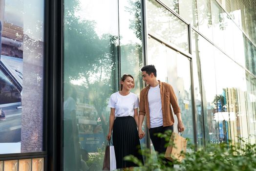 Young happy couple with shopping bags in the city.