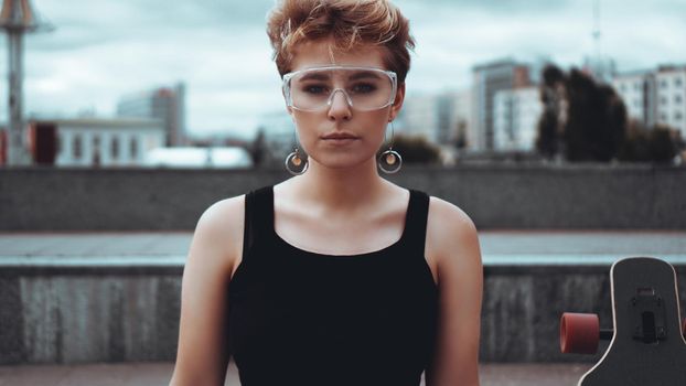 Young woman with trendy short blonde hair and plastic glasses outdoor portrait at city