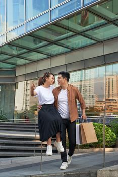 Young happy couple with shopping bags in the city,having fun together