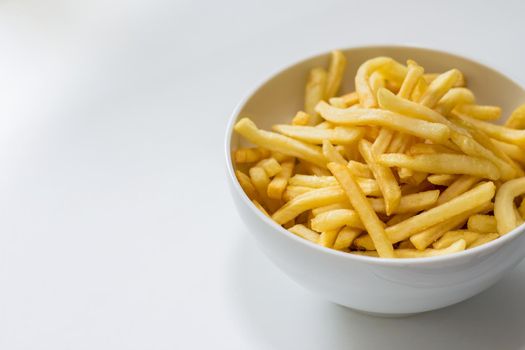 Full bowl of french fries on a white background