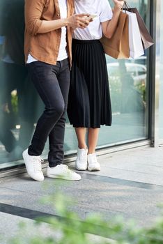 A picture of a couple shopping with smartphone in the city 