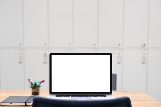 Laptop or notebook with blank screen on wood table with house or office modern.