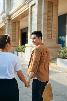 Couple with shopping bags holding hands at shopping mall