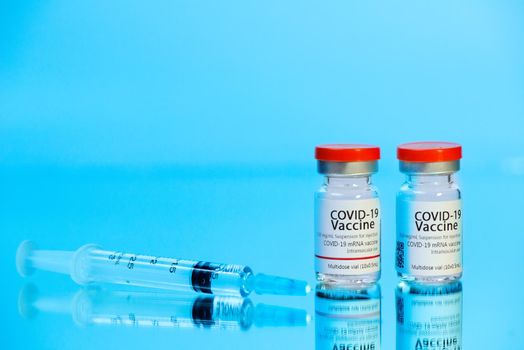 Ampoules with COVID-19 coronavirus vaccine, with a syringe for vaccination. Healthcare And Medical concept.