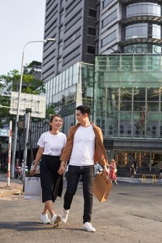 Young Asian couple going out for shopping on Le Loi road in Hochiminh city, Vietnam