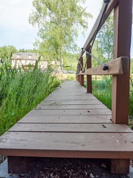 Romantic garden with wooden footbridge. Morning walk in the garden