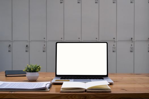 Laptop computer white screen on wooden desk in coffee shop. freelance and work from anywhere concept