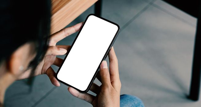 mockup image blank white screen for advertise. woman hand texting using mobile on desk at coffee shop.