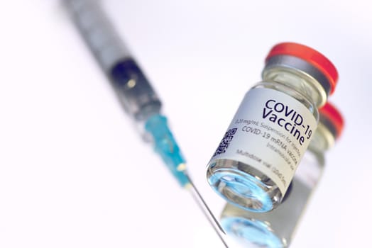 Ampoules with COVID-19 coronavirus vaccine, with a syringe for vaccination. Healthcare And Medical concept.