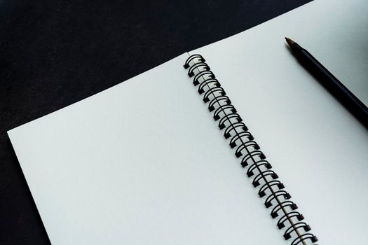 White notebook with dark background. Space for text