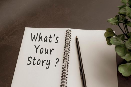 What is your story text on notebook with green leaf and dark background