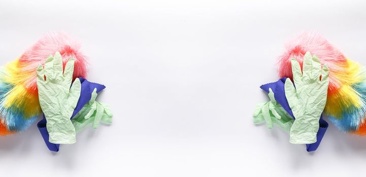 Rubber gloves, the duster and microfiber cloth on light background. Symmetrical long banner