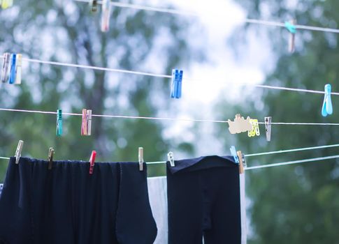 Colorful laundry hanging on the rope outdoors. The process of air drying clothes