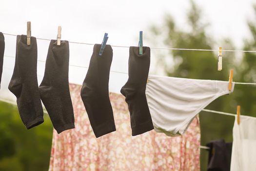 Colorful laundry hanging on the rope outdoors. The process of air drying clothes