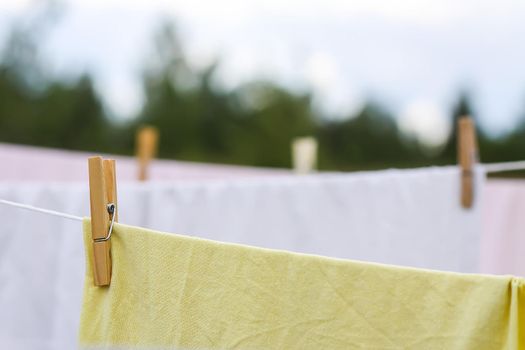 Washed colorful cotton bed sheets hanging on a clothesline outdoors