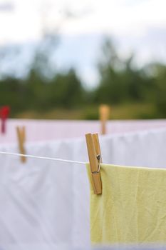 Washed colorful cotton bed sheets hanging on a clothesline outdoors