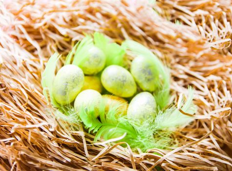 Easter composition with traditional decor. Small decorative colorful eggs on soft artificial hay.