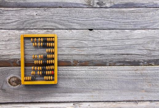 Vintage wooden abacus on old board surface.