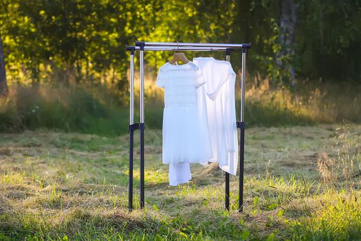 Linen dresses hanging on a hanger outdoors in summer day