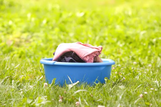 Stack of clean laundry in the large plastic cup outdoors.