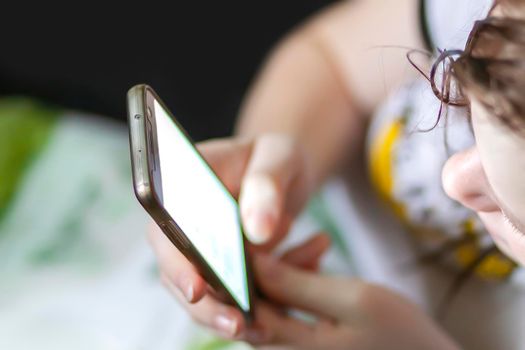 Teenager girl holding smartphone in her hands.