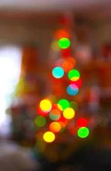 Defocused ligths of Christmas tree in the rural house interior.