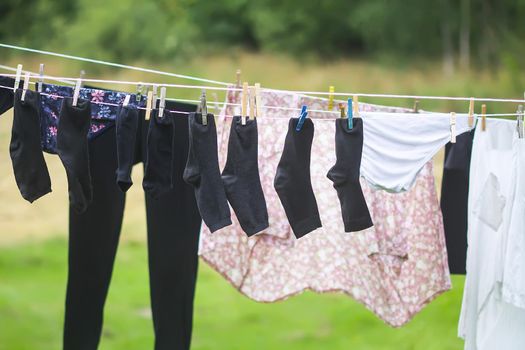 Colorful laundry hanging on the rope outdoors. The process of air drying clothes