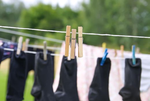 Colorful laundry hanging on the rope outdoors. The process of air drying clothes