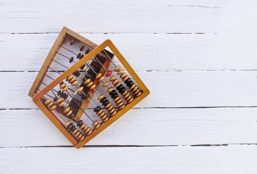 Vintage wooden abacus on white board surface.