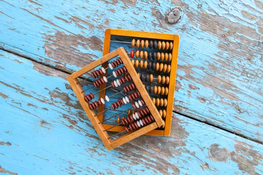 Vintage wooden abacus on oaged blue board surface.