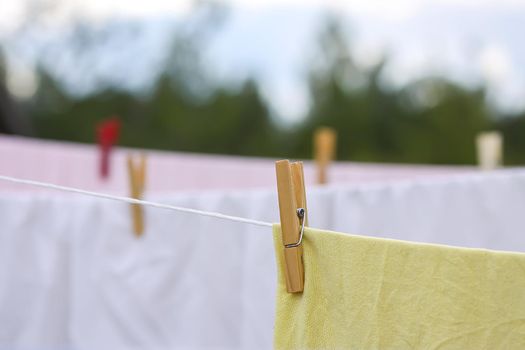 Washed colorful cotton bed sheets hanging on a clothesline outdoors