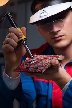 Computer specialist repairing PC late at night