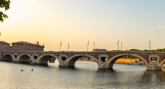 Sunset in the Garonne river and its bridges in Toulouse in Haute-Garonne, Occitania, France.