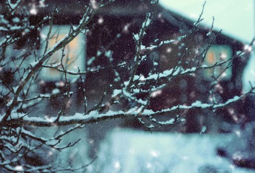 Christmas lantern with burning candle on winter snowfall background.