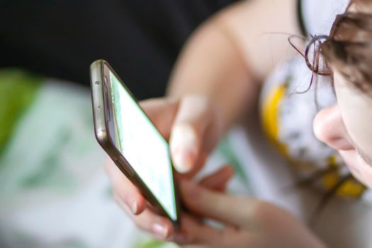 Teenager girl holding smartphone in her hands.