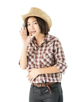 Young pretty woman in a cowboy hat and plaid shirt with hand on her hat isolated on white background