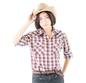 Young pretty woman in a cowboy hat and plaid shirt with hand on her hat isolated on white background