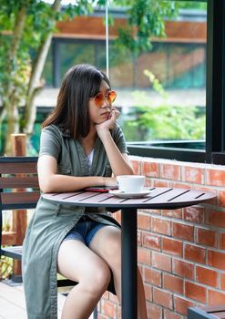 Pretty woman sitting in a cafe terrace with coffee cup