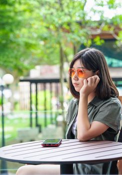 Pretty woman sitting in a cafe terrace use smartphone