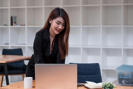 Portrait Of Attractive Asian Businesswoman Working On Laptop for marketing plan